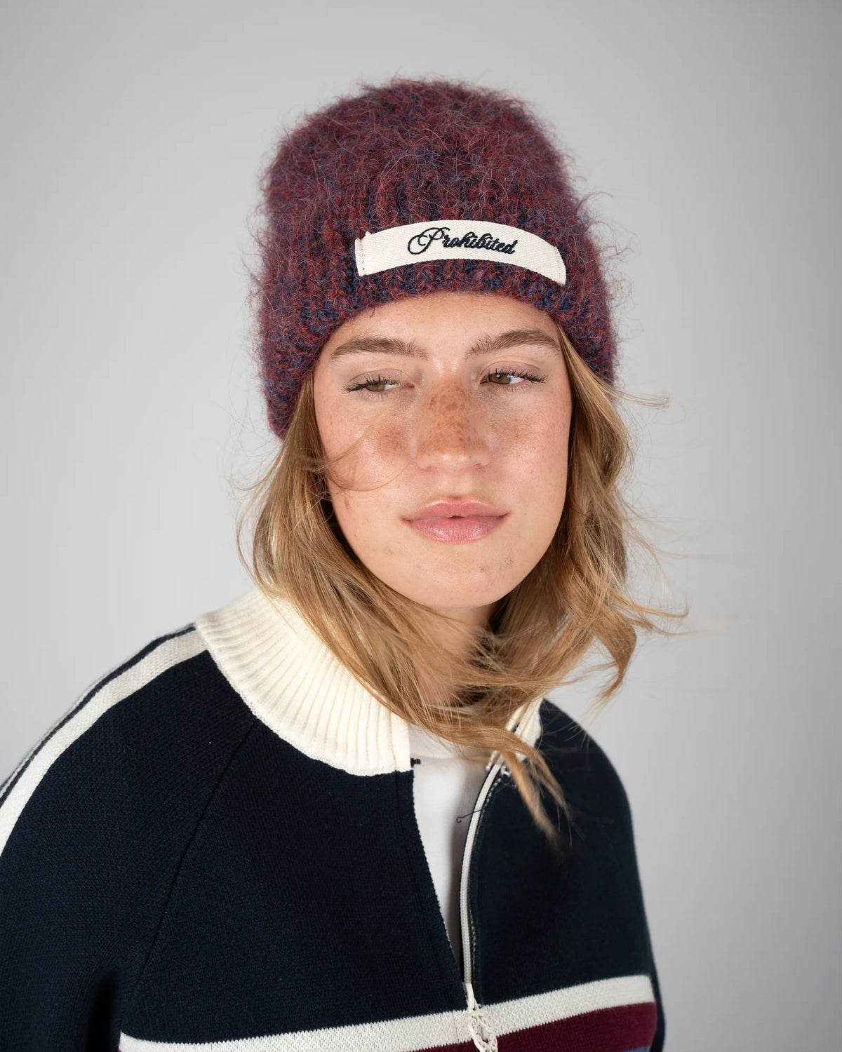 Prohibited Season Knit Beanie in rood/blauw, gedragen door model